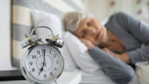 Elder sleeping with clock in view